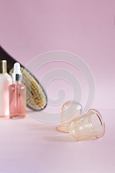 Silicon vacuum cuppings and defocused mochup bottles, dry massage brush, woman body and skincare things, items for cellulite, on photo