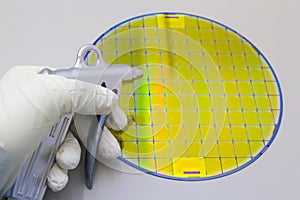 Silicon Wafer cleaning by nitrogen from gun for cleanroom in the hands by gloves - A wafer is a thin slice of semiconductor