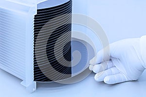 Silicon wafer inspection. A batch of silicon wafers packed in a plastic storage box in the clean room of a semiconductor