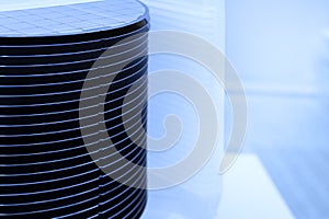 Silicon wafer inspection. A batch of silicon wafers packed in a plastic storage box in the clean room of a semiconductor