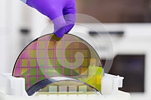 Silicon Wafer with semiconductors in plastic white storage box take out by hand in gloves inside clean room