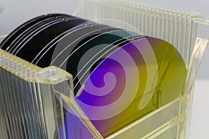 Silicon Wafers in plastic storage box in clear room of semiconductor foundry.