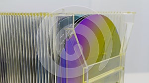 Silicon Wafers in plastic storage box in clear room of semiconductor foundry.