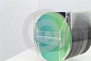 Silicon Wafers in plastic storage box in clear room of semiconductor foundry.