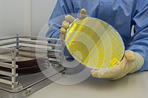 Silicon Wafers in steel holder box take out by hand in gloves- A wafer is a thin slice of semiconductor material, such