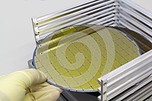 Silicon Wafers in steel holder box take out by hand in gloves- A wafer is a thin slice of semiconductor material, such as a