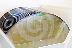 Silicon Wafers in white plastic holder box on a table- A wafer is a thin slice of semiconductor material, such as a crystalline