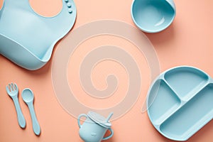 Silicone baby tableware set on color background. Flat lay, top view