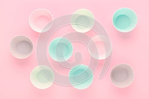 Silikone forms for baking muffins and cupcakes on pastel pink background