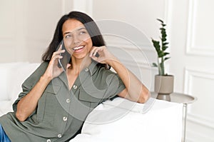 Siling young mixed-race woman talking by smartphone