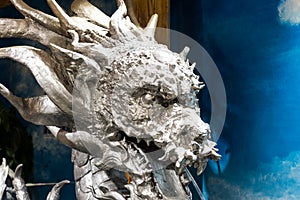 A siliver Chinese dragon head statue in front of a shop in Beijing,China