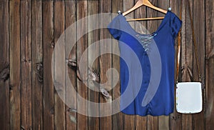 Silk blue blouse, bag on a brown background