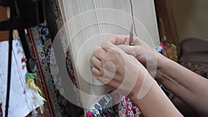 Silk carpet with hand woven. Two women are weaving silk carpet by hand