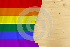 Silk colored LGBT rainbow flag, Pride flag, empty wooden mocap for text, concept of tourism, travel, emigration, global business,