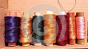 Silk and cotton threads for sewing and embroidery. Spools with multi-colored threads.