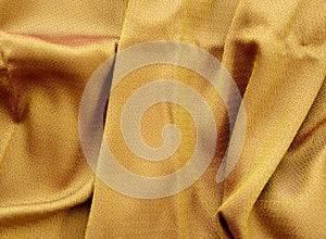 Silk golden fabric texture close up.