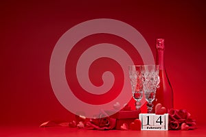 Silk hearts, champagne and flutes, gifts, calendar with date 14 february on red background with copy space. Valentine`s Day