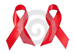 A silk red ribbon in the form of a bow is isolated on a white background, a symbol of the fight against AIDS and a sign of