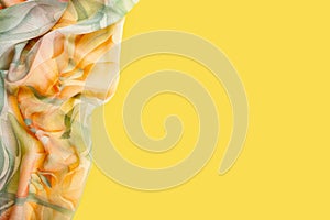 Silk scarf. Yellow silk scarf isolated on yellow background