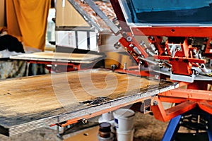 Silk screen textile printery. print screening apparatus selective focus photo. serigraph printing production. manual screen photo