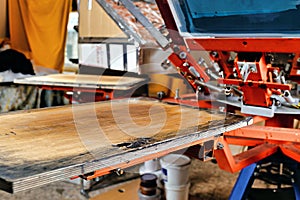 Silk screen textile printery. print screening apparatus selective focus photo. serigraph printing production. manual screen