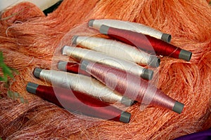 Silk thread in roller with orange background.
