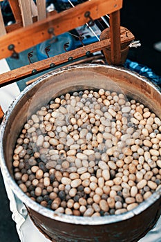 Silkworm cocoons in hot water in cauldron