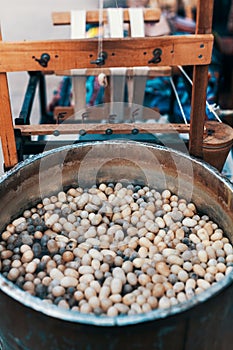 Silkworm cocoons in hot water in cauldron