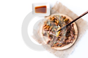 Silkworm pupa on chopsticks