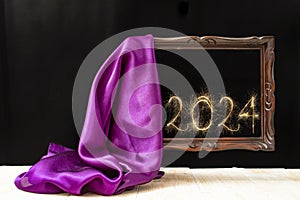 silky fabric unveiling an levitating wooden frame, with 2024 new year  number written with sparker firework