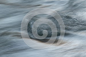 Silky water surface detail from rapid mountain stream in long exposure