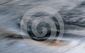 Silky water surface detail from rapid mountain stream in long exposure