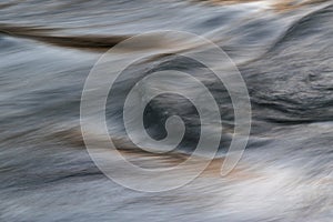 Silky water surface detail from rapid mountain stream in long exposure