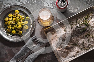 Sill life with fish , Brussels sprouts and beer on the stone background top view