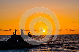 Sillhouette of people in the beach during sunset