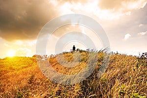 Sillouette man stand on peak mountain meadow golden photo