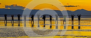 Sillouette of tourists posing as a groun on Bolivian Salt Flats in Bolivia