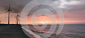 Sillouette of Wind turbine array at seashore