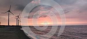 Sillouette of Wind turbine array at seashore