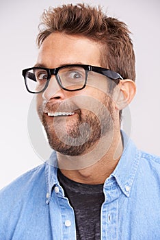 Silly face, nerd and man with glasses, portrait and goofy guy on a grey studio background. Model, eyewear and person