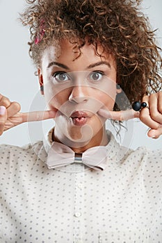 Silly, goofy and portrait of woman in studio with fingers in her cheeks for funny face expression. Fashion, funky and