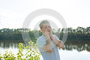 Silly man making funny face or grimace over nature background