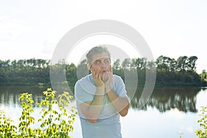 Silly man making funny face or grimace over nature background