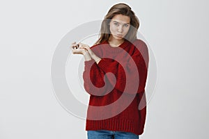 Silly and playful woman in red loose warm sweater making flirty glances at camera folding lips kissing sending air