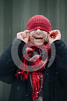 Silly portrait of a positive middle age man with winter hat over his eyes