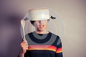 Silly young man with pot on his head