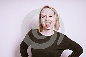 Silly young woman sticking out tongue and winking