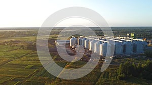 Silo towers for feed storage in the field near the town with sunset light