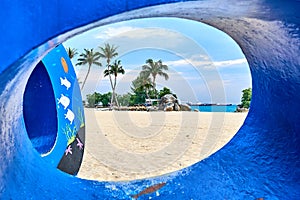 Siloso Beach seen through the hole of a structure on the beach