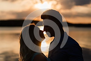 Silouette, loving couple on the lake during sunset. Golden hour photo